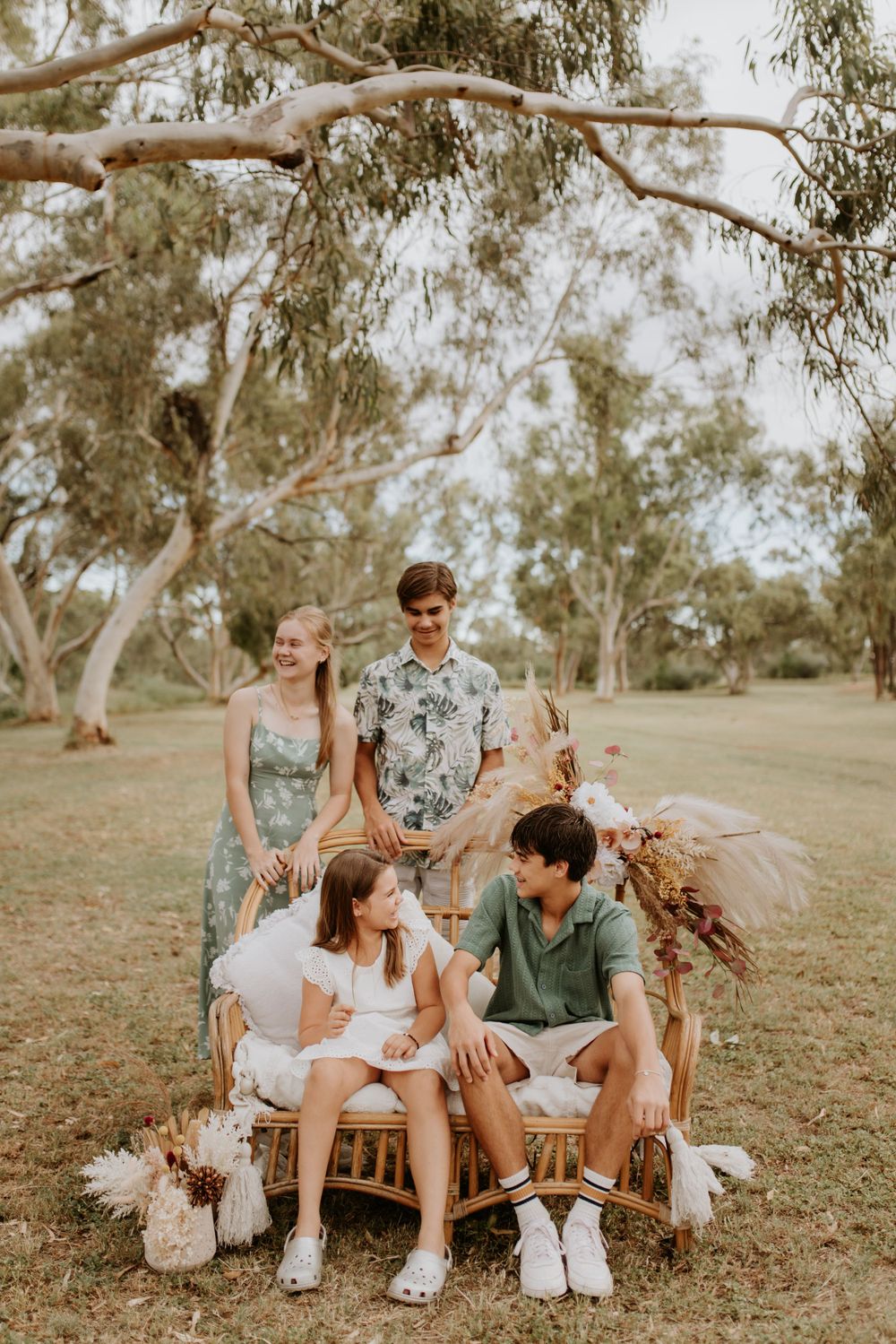4 siblings sit and stand in the park in mount isa