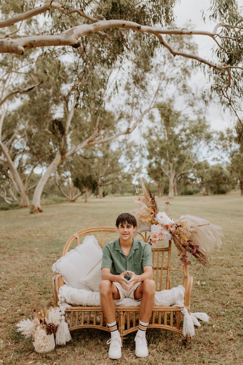 young boy sitting on cane chair in the park in mount isa