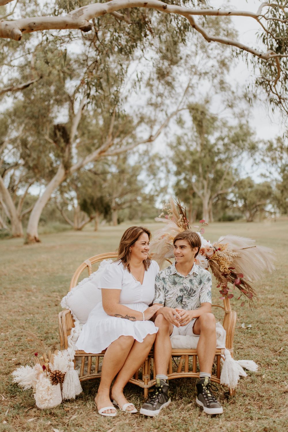 mother and son sitting on cane chair in the park in mount isa