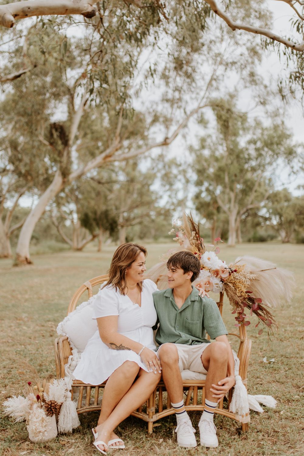 mother and son sitting on cane chair in the park in mount isa