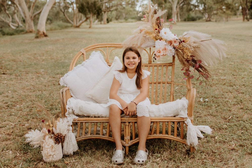 young girl sitting on cane chair in the park in mount isa