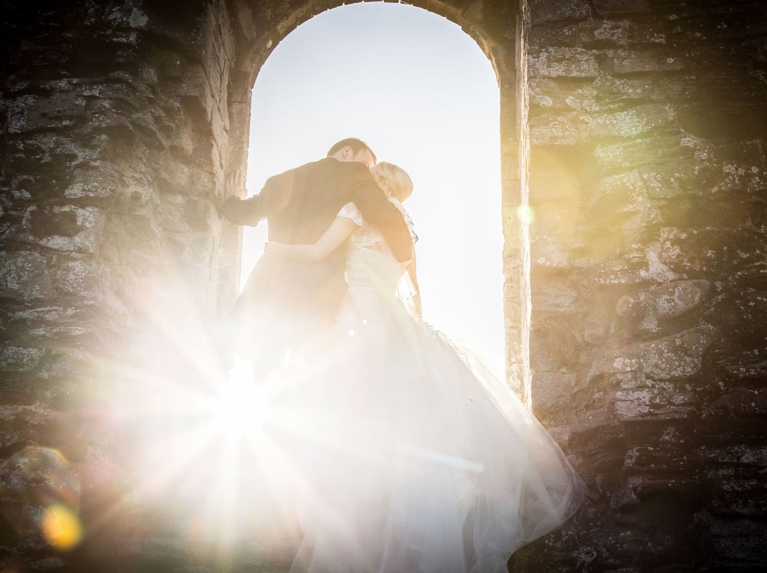Silhouetted figures embrace in dramatic backlit window scenes creating romantic wedding moments.