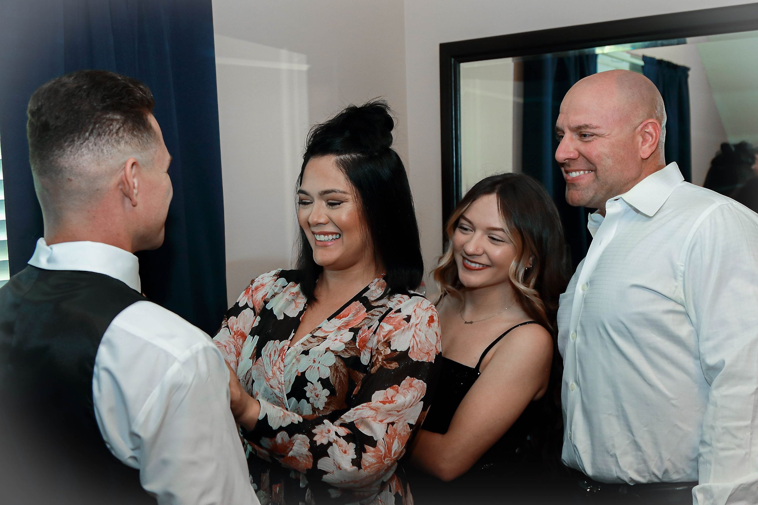 Small group shares laughs during casual indoor gathering.