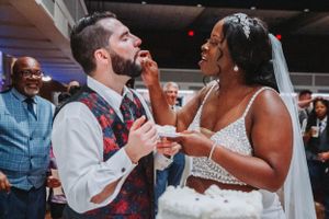 Playful cake feeding moment during a wedding reception celebration.