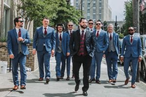 Groomsmen walking down a city street in coordinated blue suits.