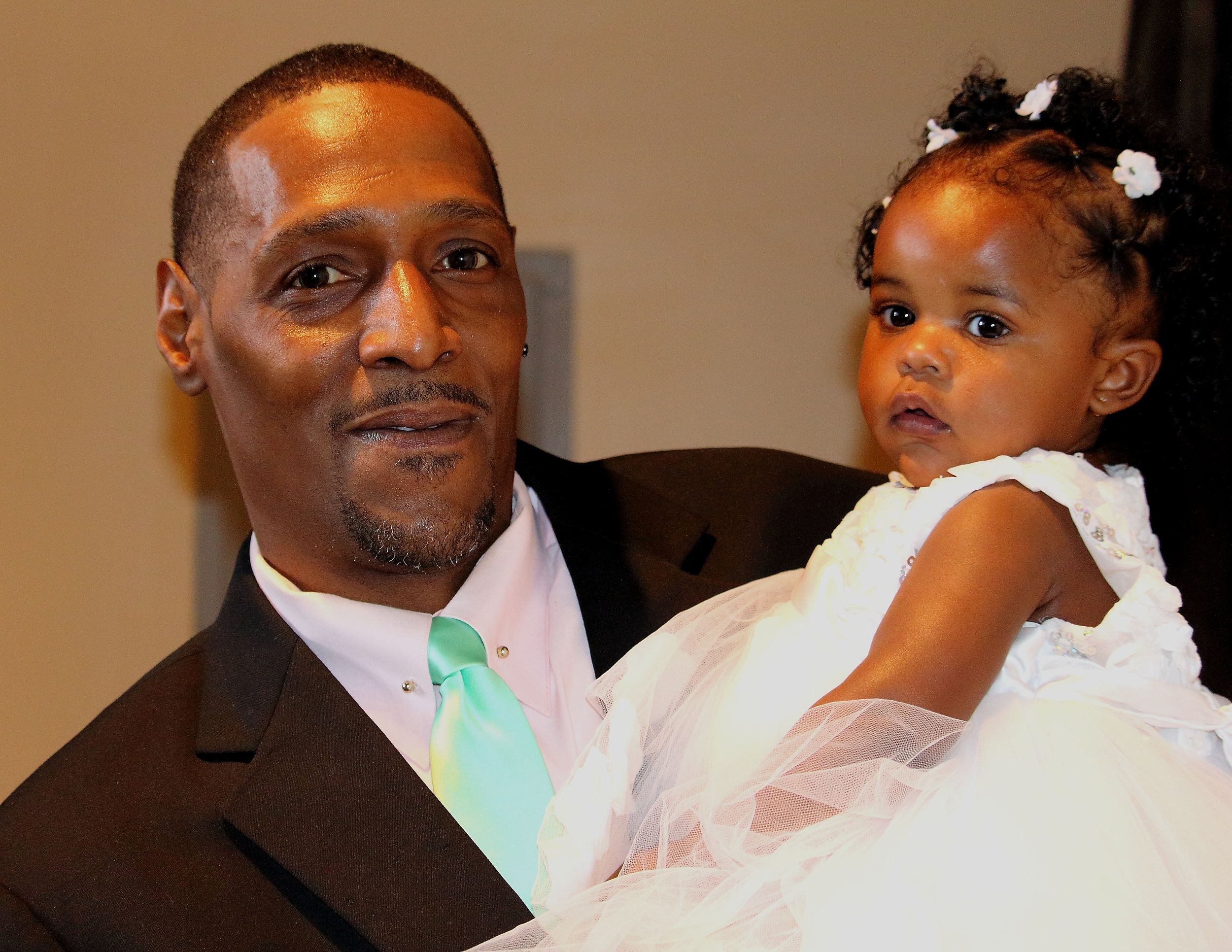 Formal portrait with white dress and suit against neutral background.