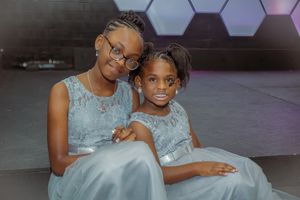 Special moment shared between two wedding attendees in matching blue-grey dresses.