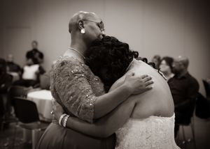 Intimate black and white emotional embrace during wedding reception.