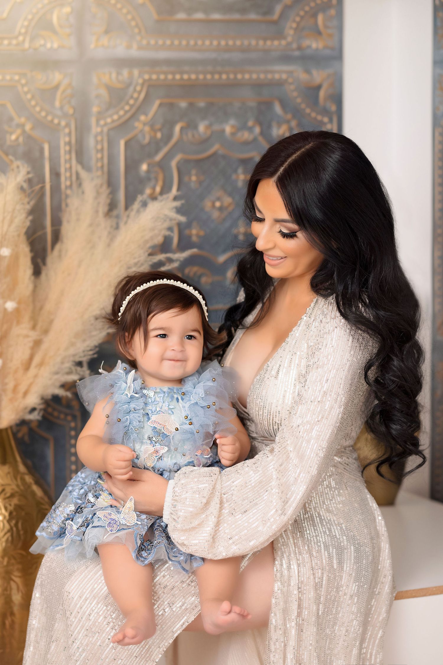 Intimate portrait with white lace dress and blue tulle dress against ornate backdrop.