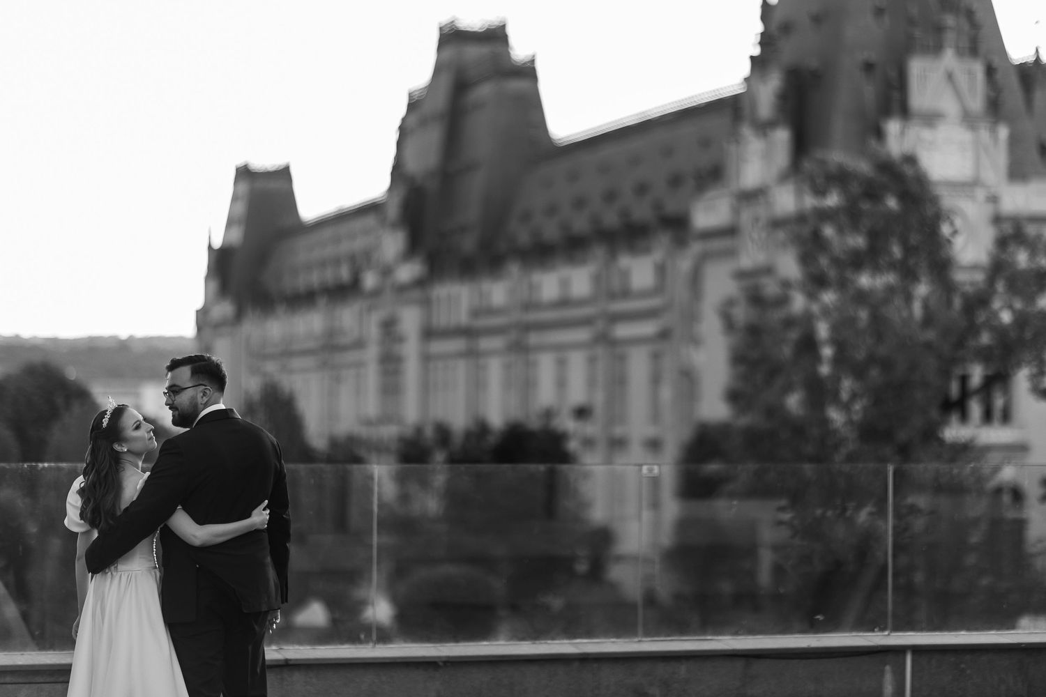 Black and white silhouette of couple standing near historic building architecture.