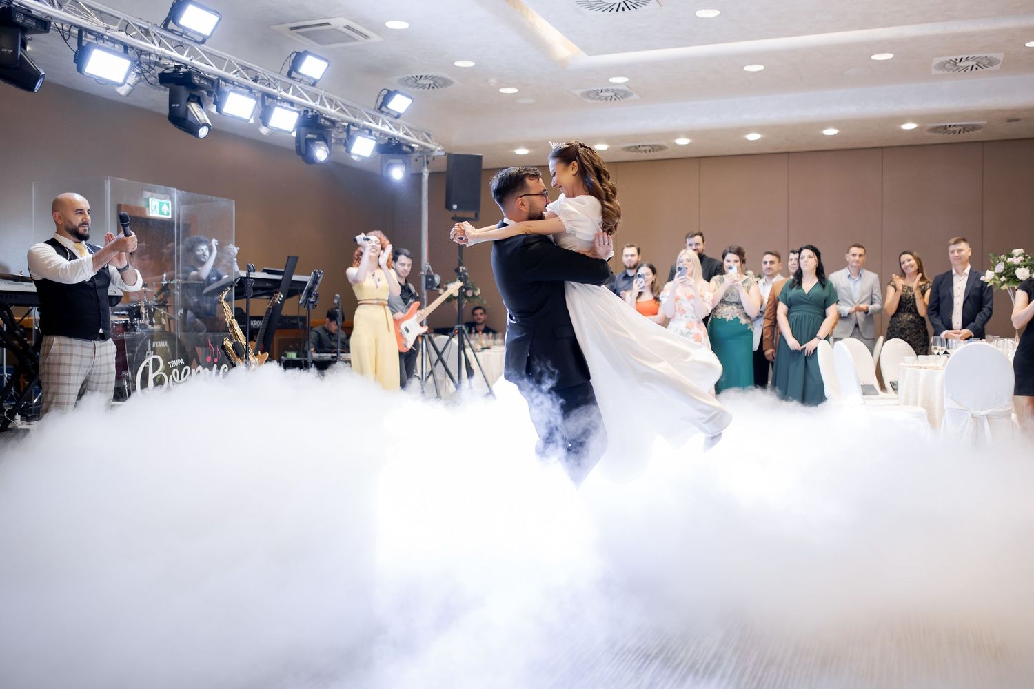 Romantic first dance with dry ice fog effects creating dreamy atmosphere at wedding reception.