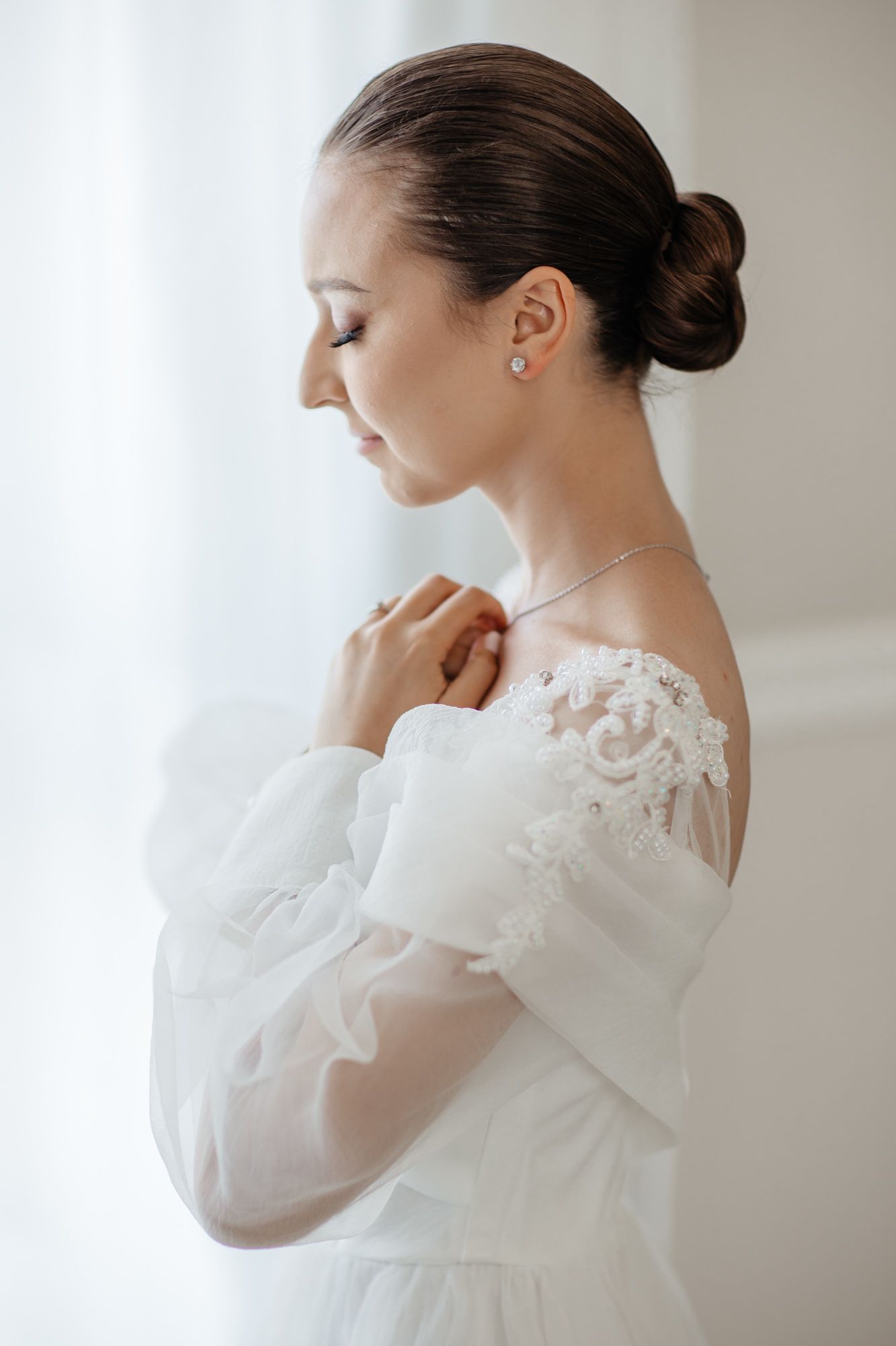 Side view of bridal portrait showing delicate lace details and classic updo.