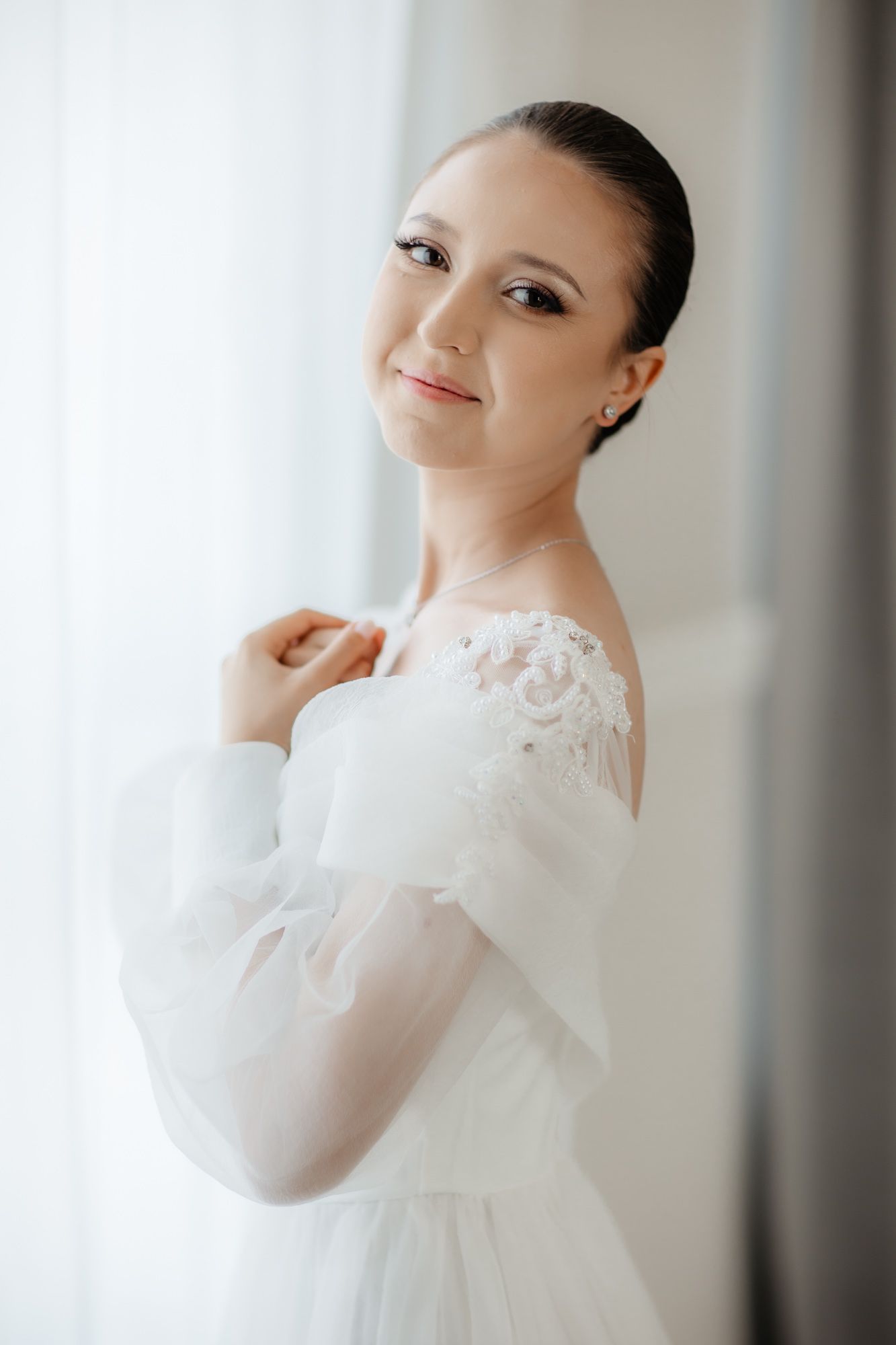 Elegant bridal portrait in a classic white wedding dress with lace details.
