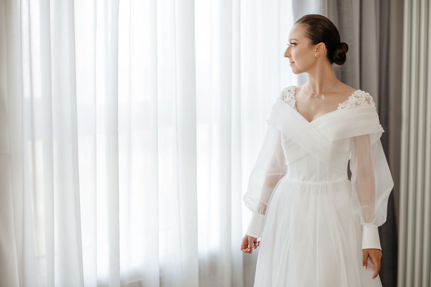 Full-length side view of wedding dress featuring long sleeves and sweetheart neckline.