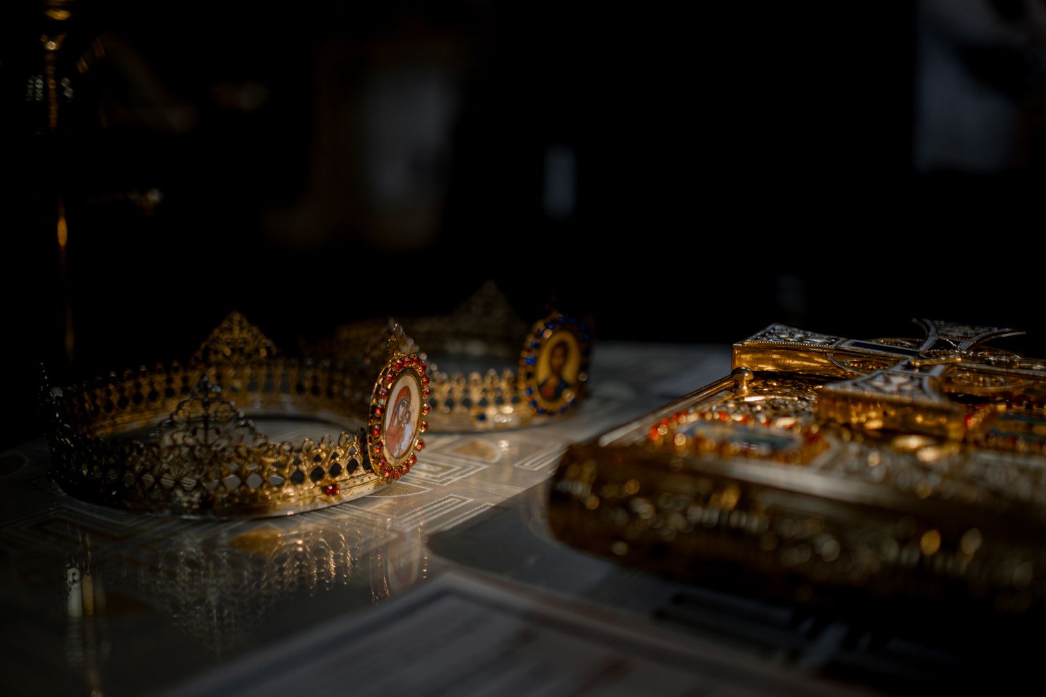 Close-up of ornate golden Orthodox wedding crowns on display.