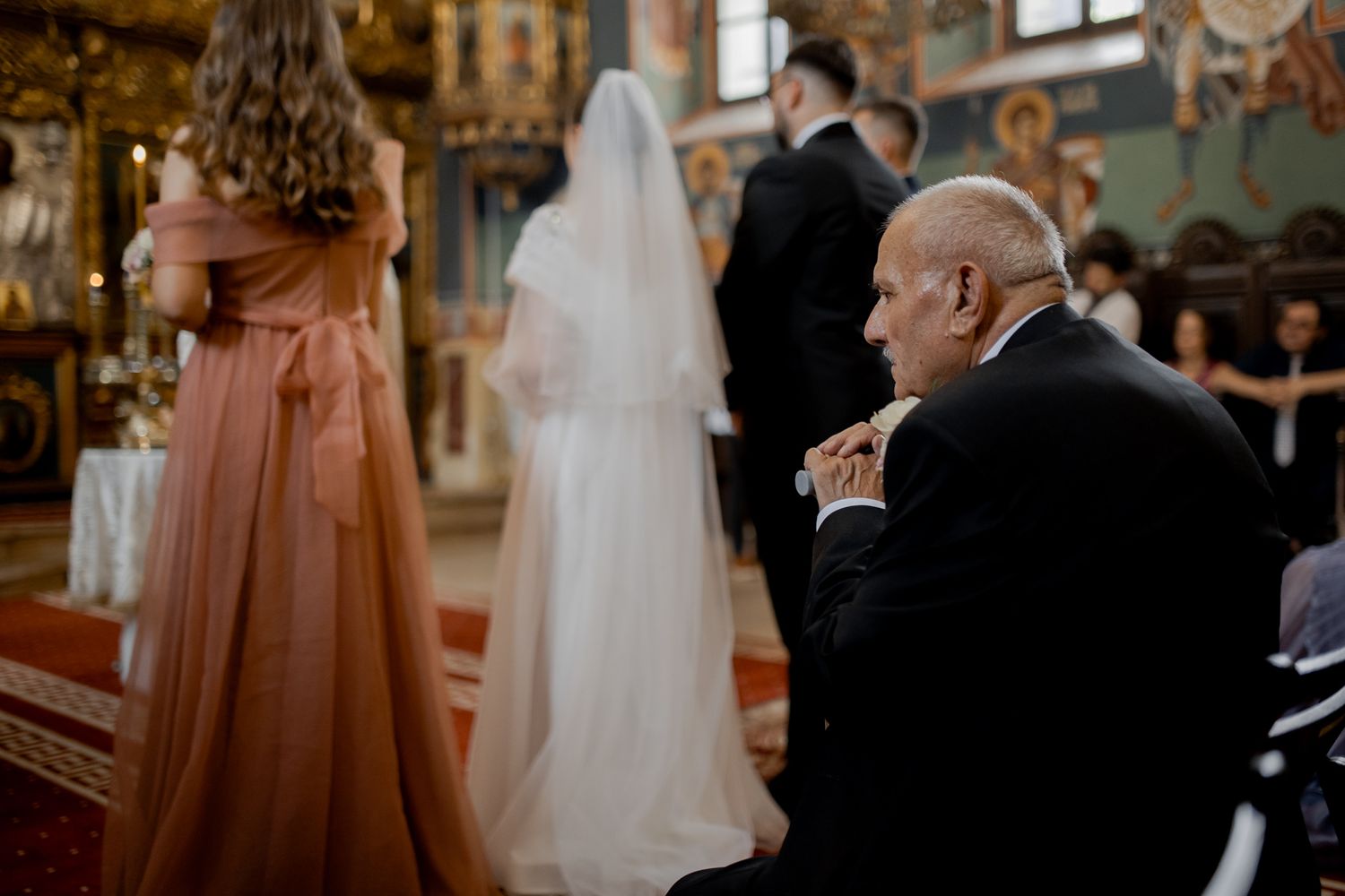 Side view of wedding ceremony in progress at historic church with decorative frescoes.