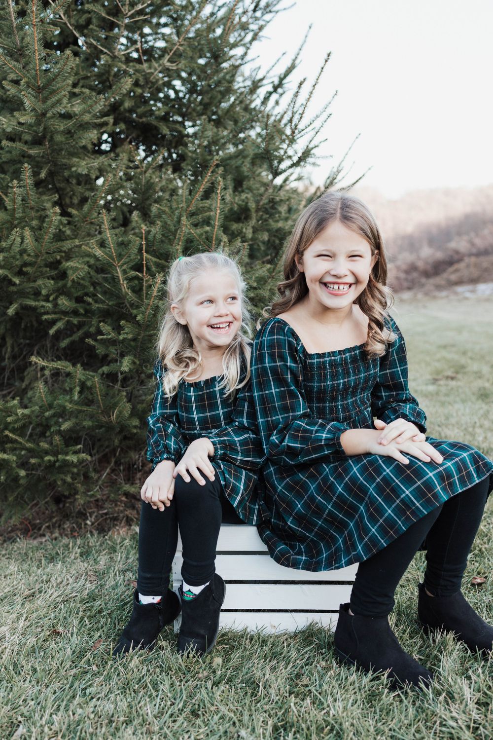 Sisters laughing in outdoor photo with matching dresses