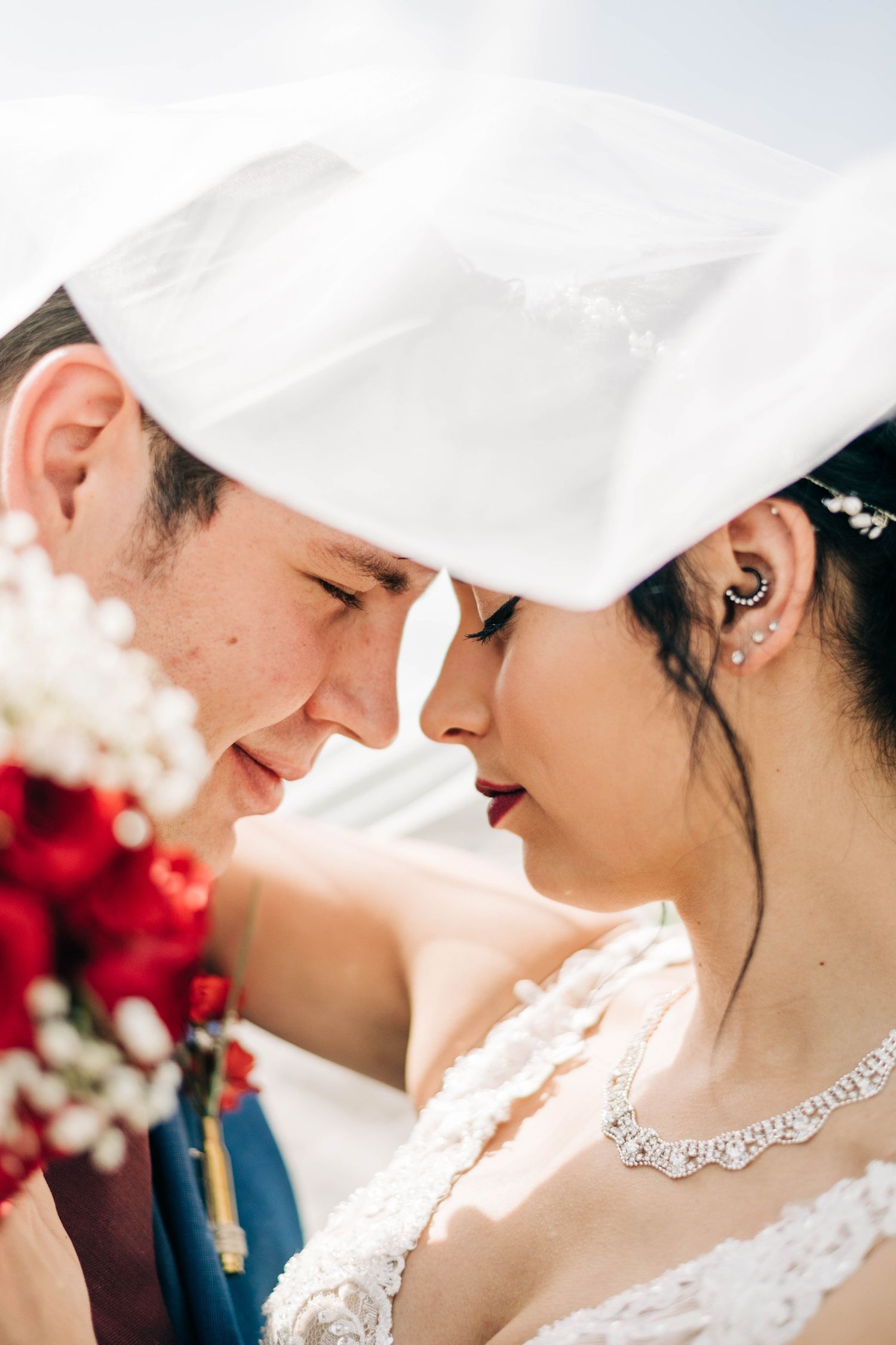 bride and groom forehead to forehead under her veil