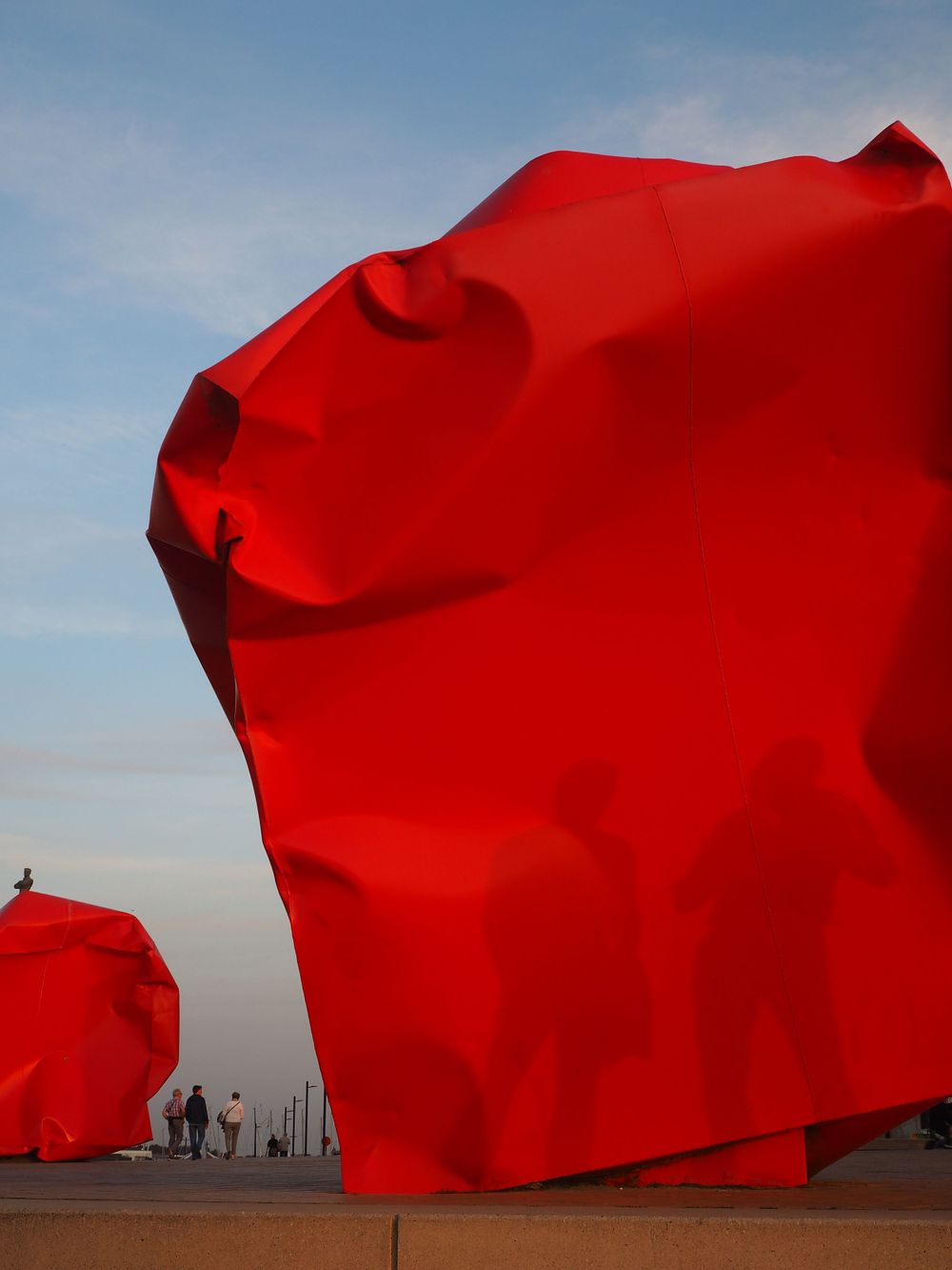 Shadow of two people over 'rock strangers' sculpture in Ostend