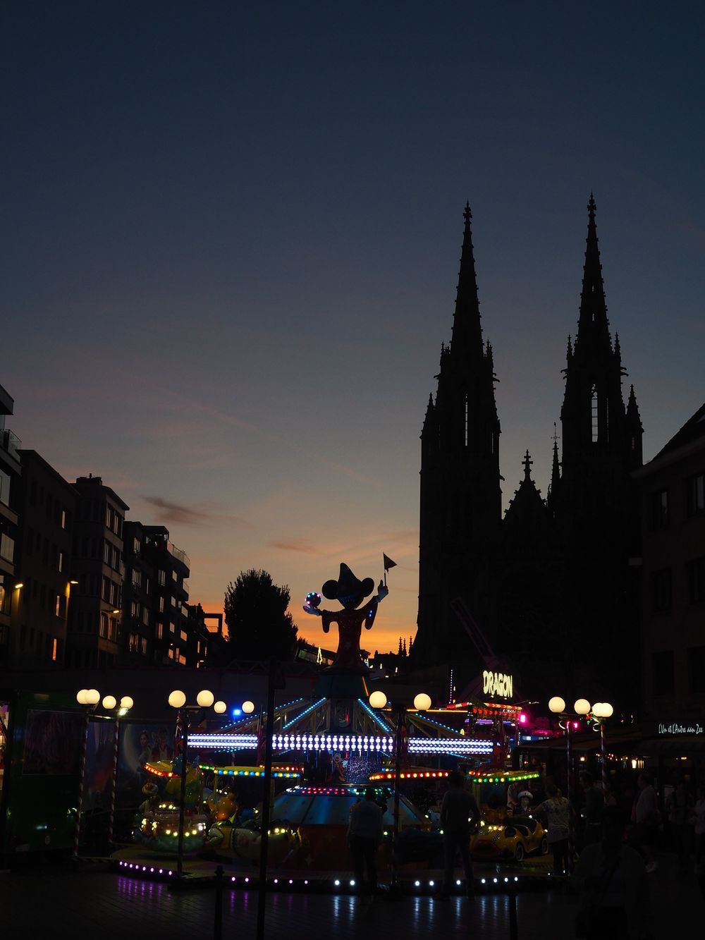 Silhouette of mickey mouse on a carousel next to a church