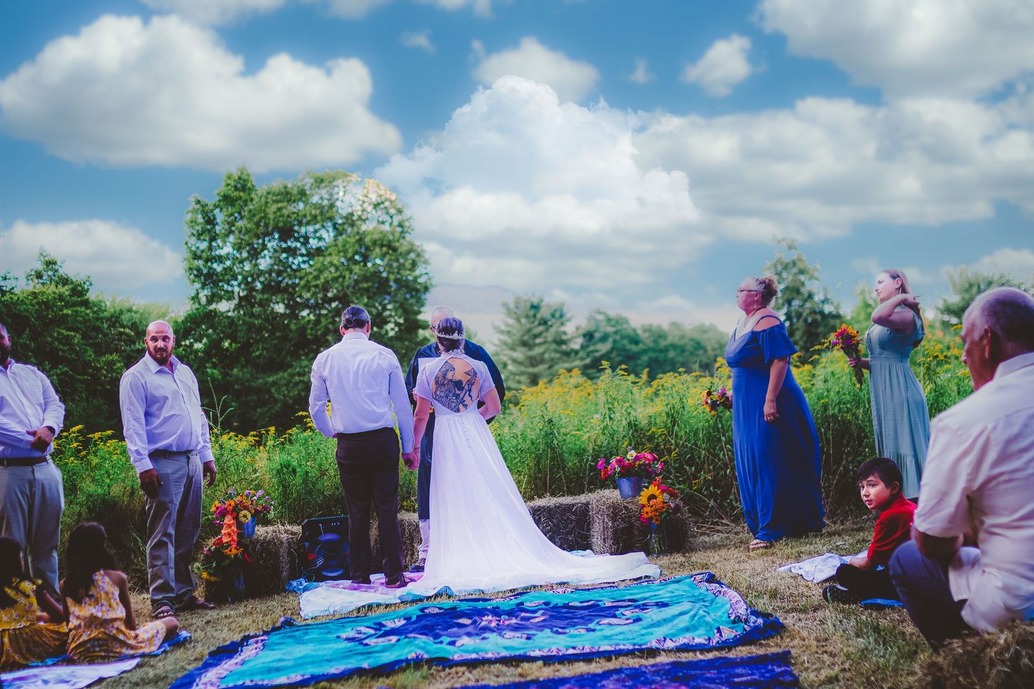 Outdoor wedding ceremony setup with blue decor and natural landscape backdrop.