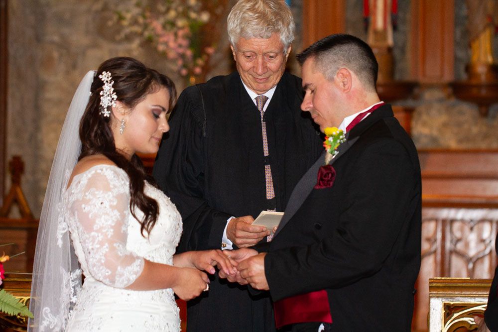 A romantic indoor wedding ceremony with elegant decor and floral arrangements.