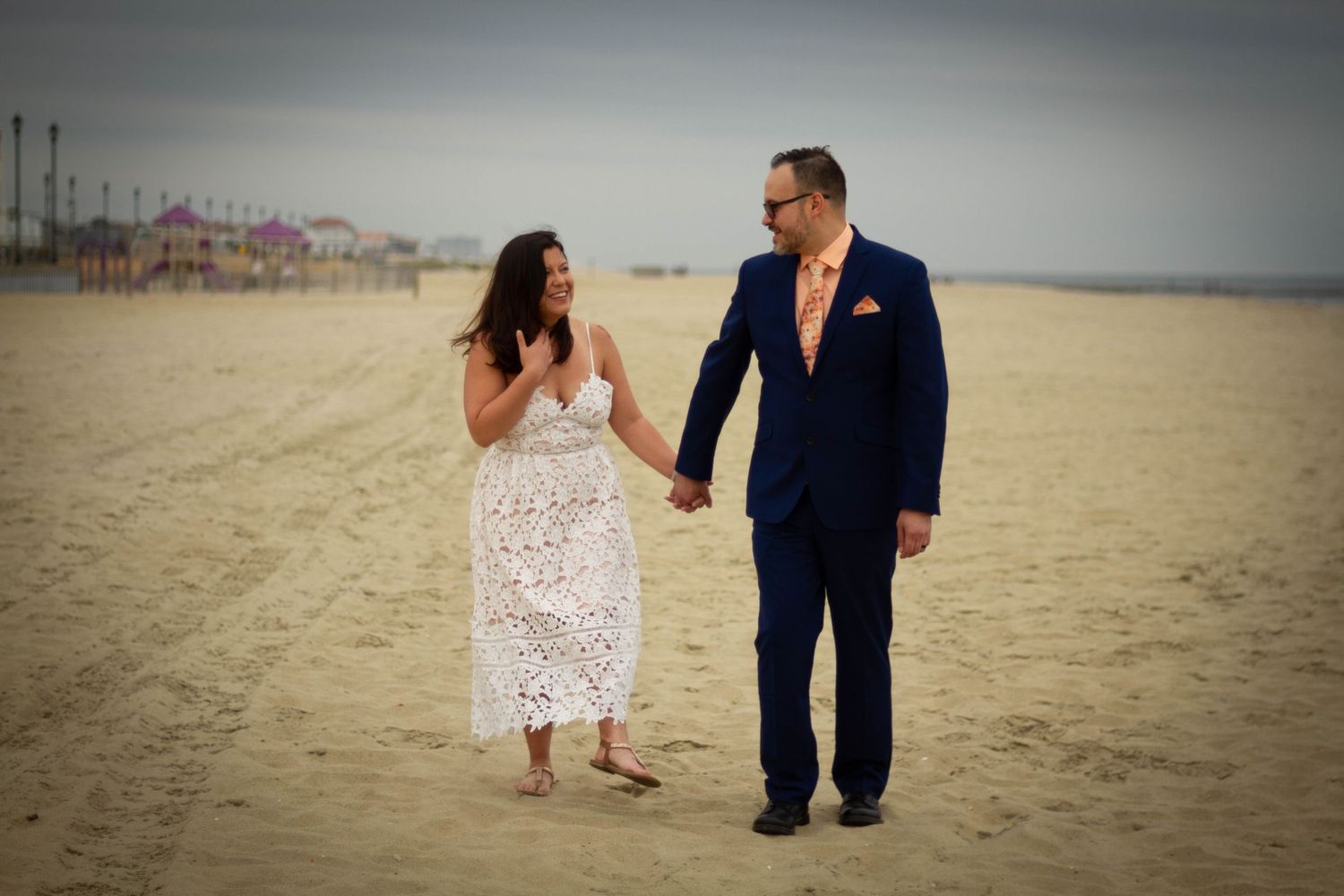 Romantic beach scene with footprints in the sand and soft lighting at sunset.