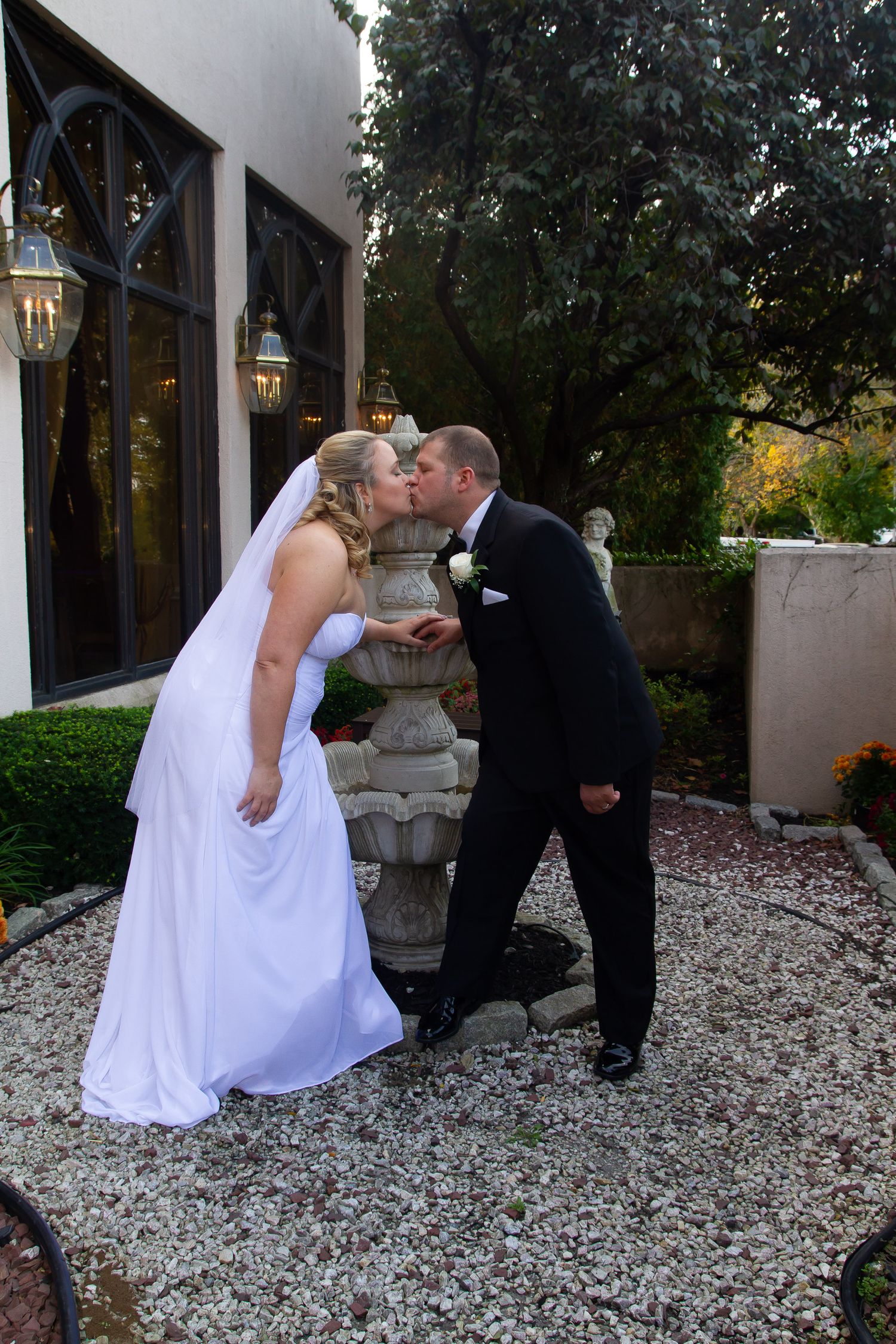 A romantic wedding photo sequence on white gravel with architectural elements.