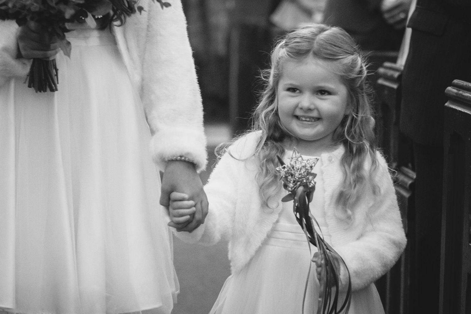 Black and white photo of a young attendant in a white fur-trimmed dress at a formal event.