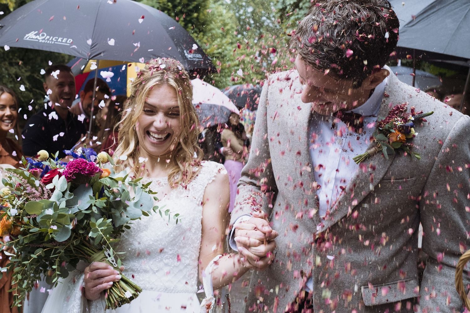 newlywed couple sprinkled with flower petals at St. Andrews church in Wraysbury