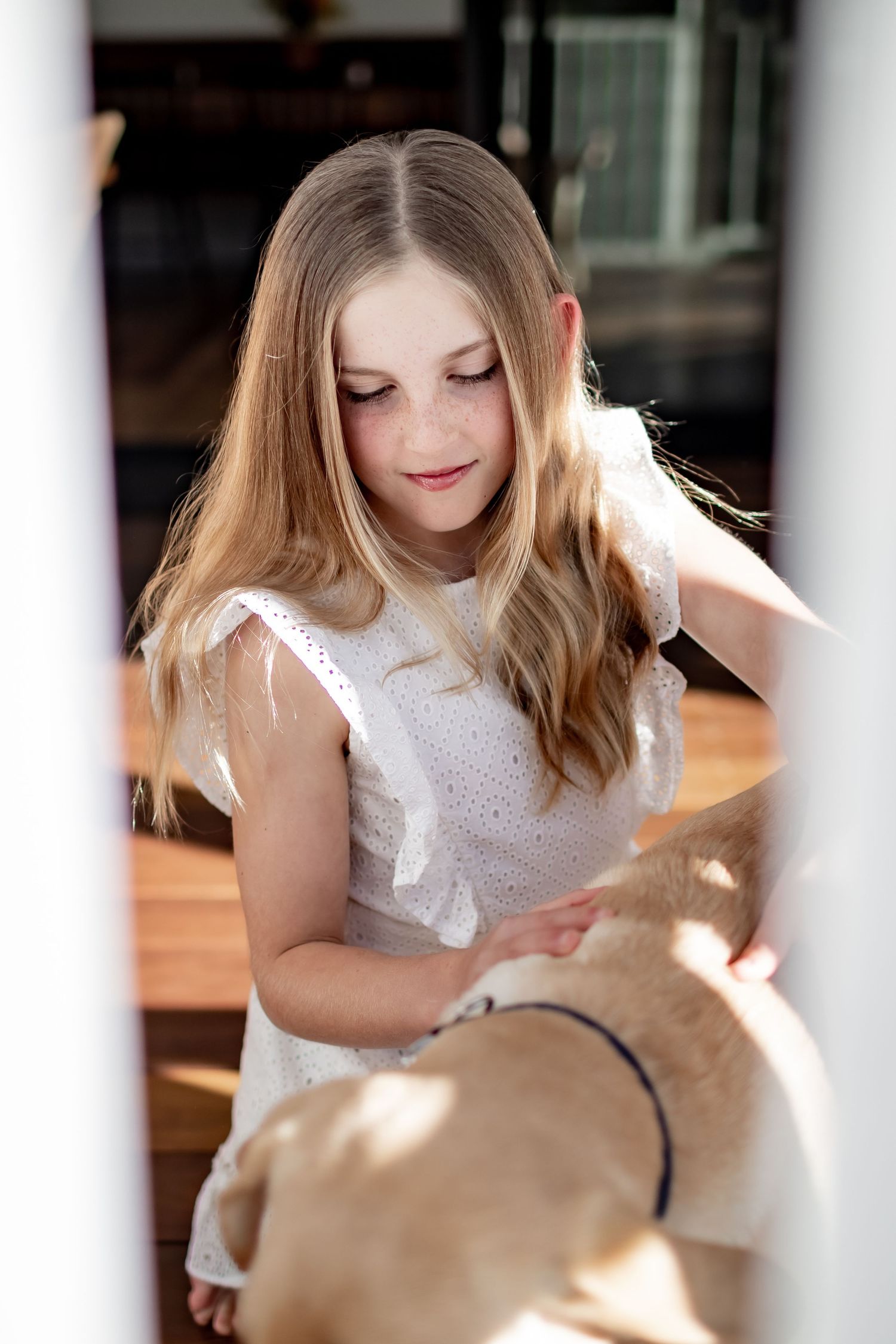 Person in white dress bathed in natural sunlight streaming through window.