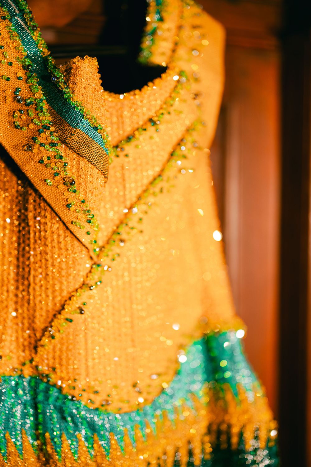 Shimmering golden yellow and turquoise beaded fabric with a chevron pattern design.