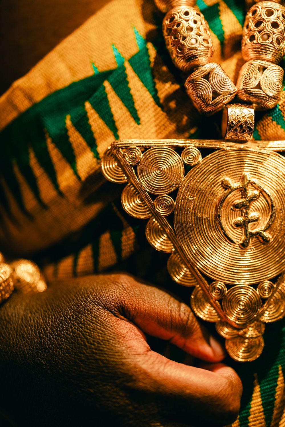 Close-up of intricate gold traditional African jewelry with spiral patterns.