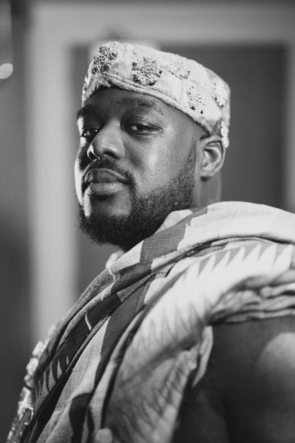 A portrait in black and white showing traditional West African attire.