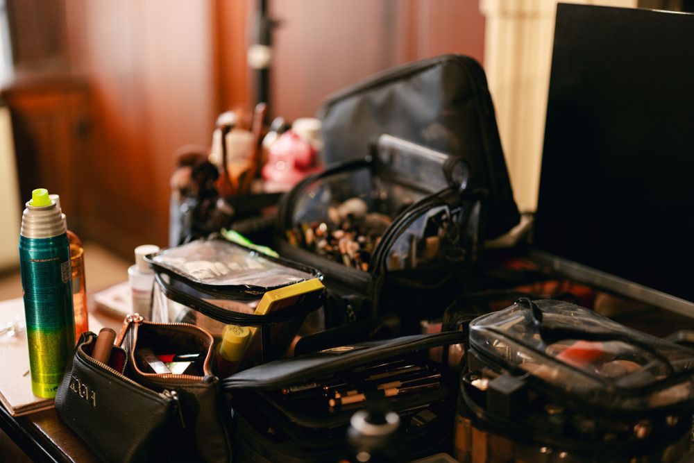 Cluttered production setup with headphones and equipment on wooden surface.