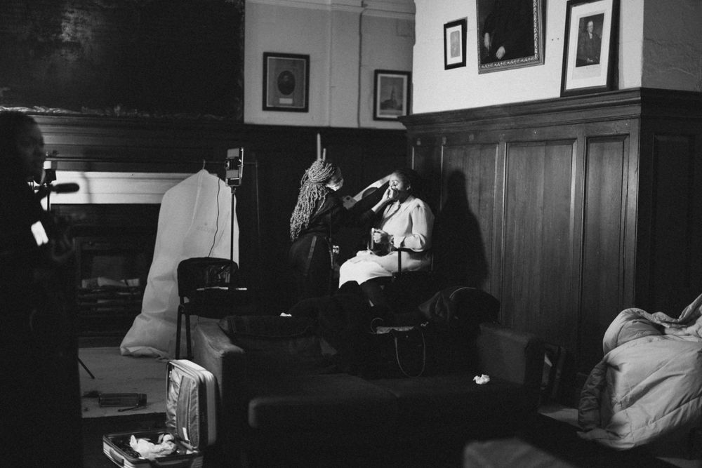 Vintage black and white photo of people in a cozy room with wood-paneled walls.