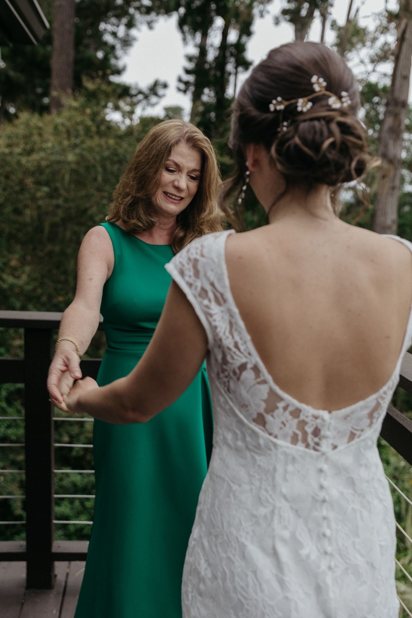 A touching moment between wedding guests on an outdoor deck.