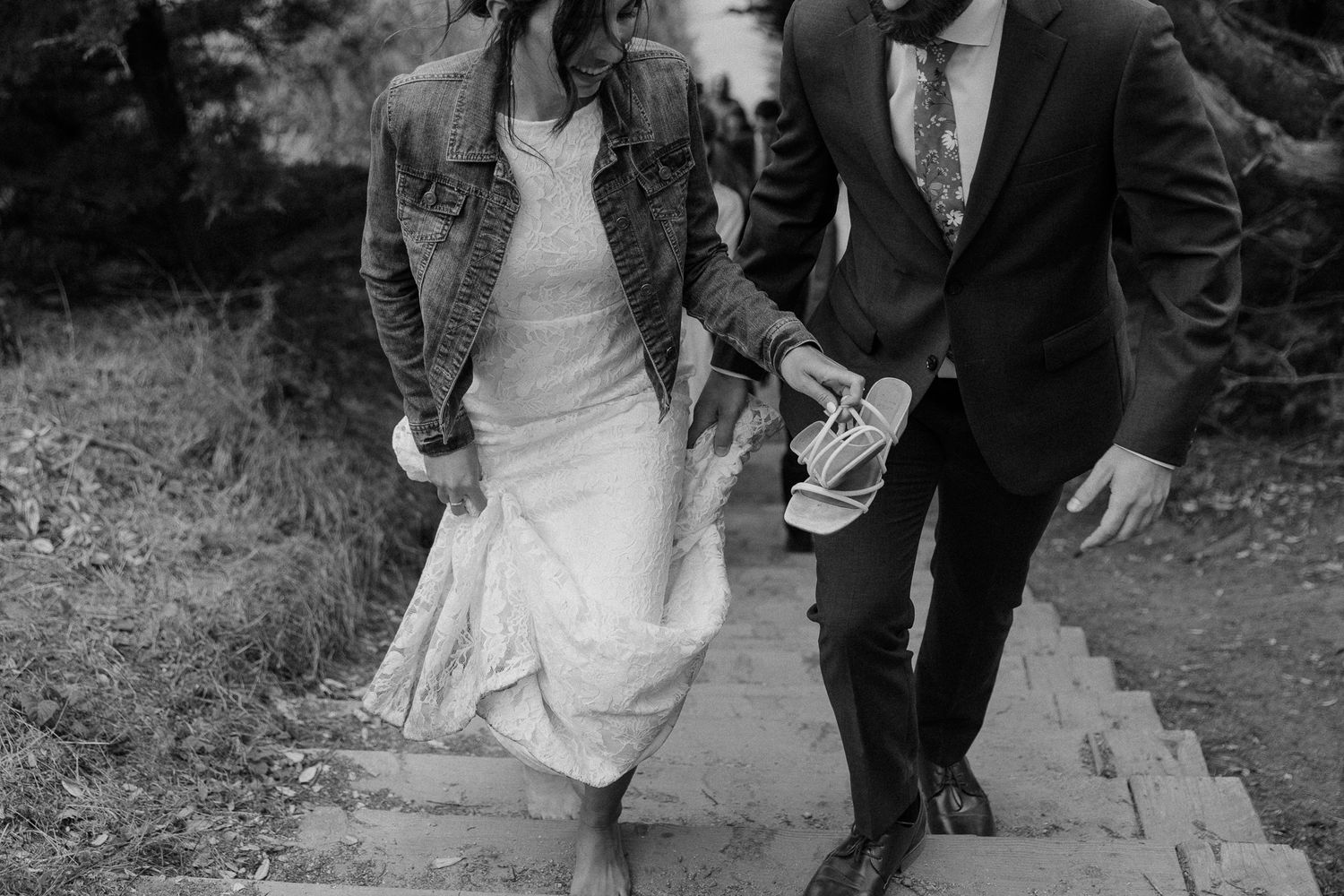 A couple walks down stone steps together during their wedding day.