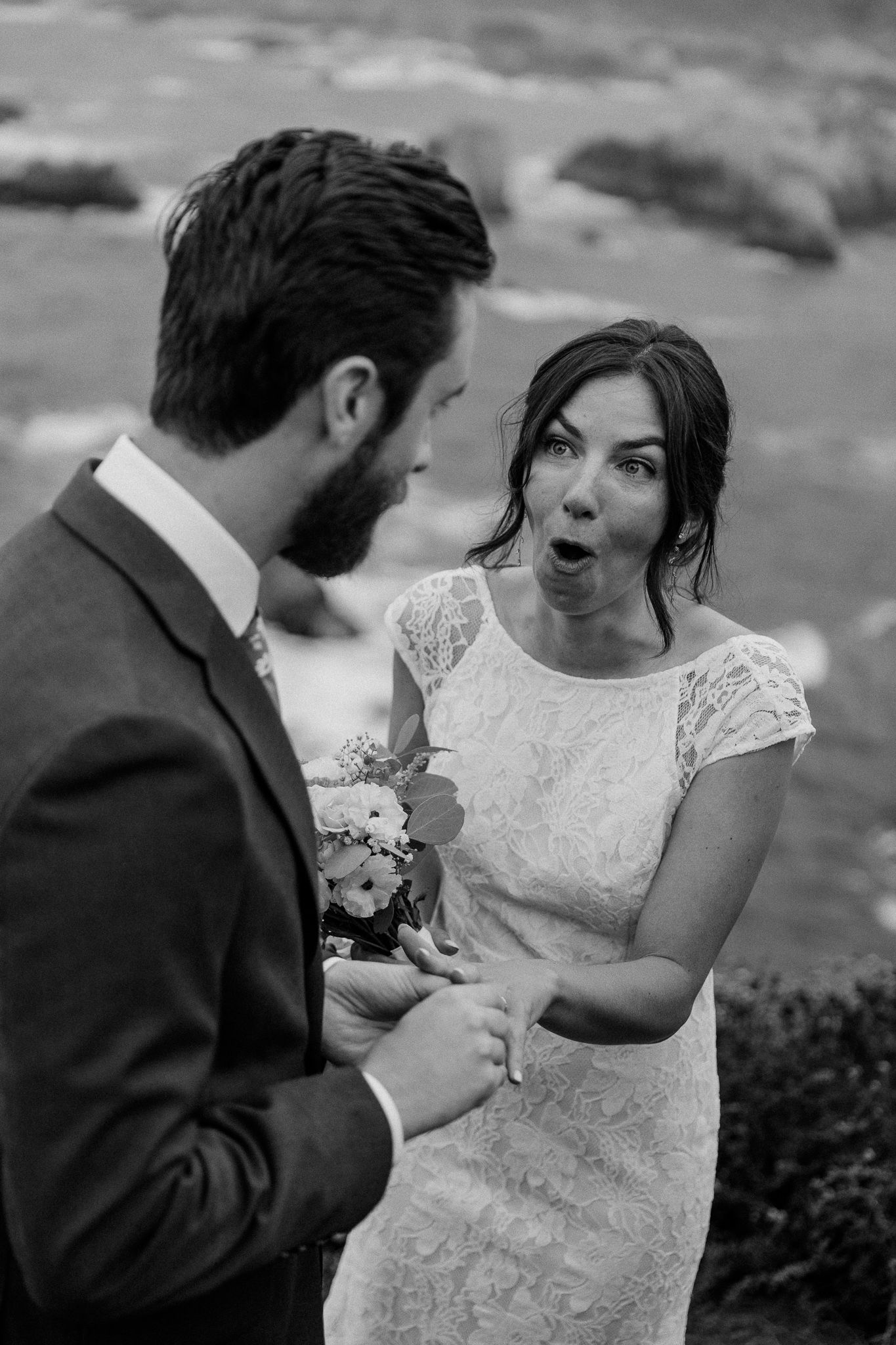 Playful moment between wedding couple during coastal ceremony.