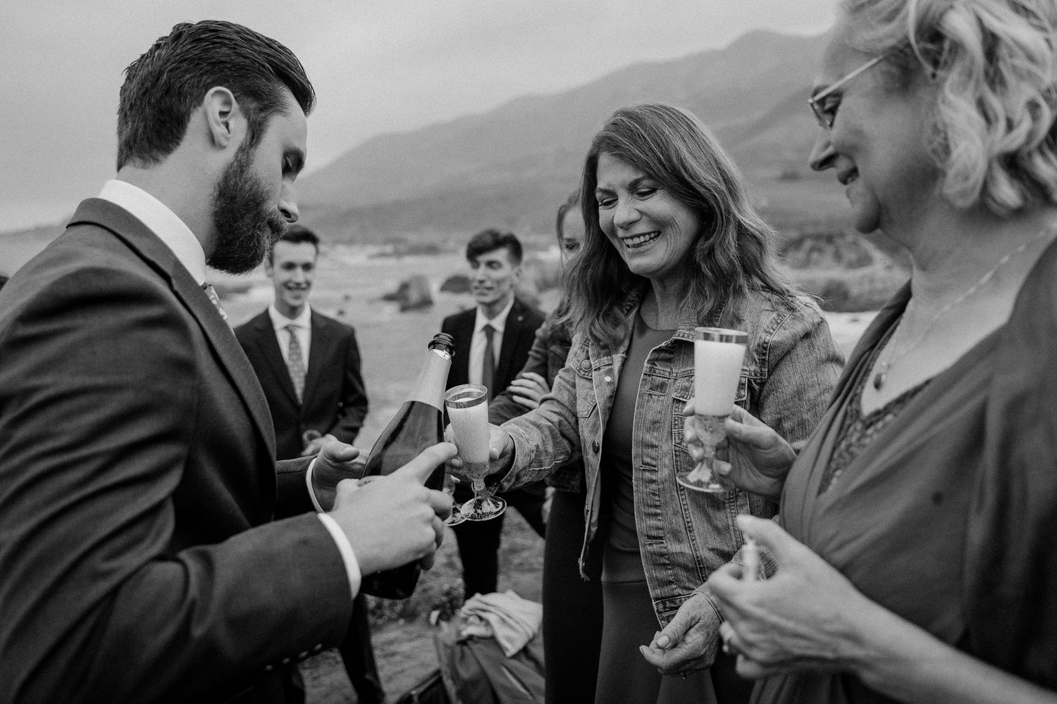 Group toasting with champagne glasses during outdoor celebration.