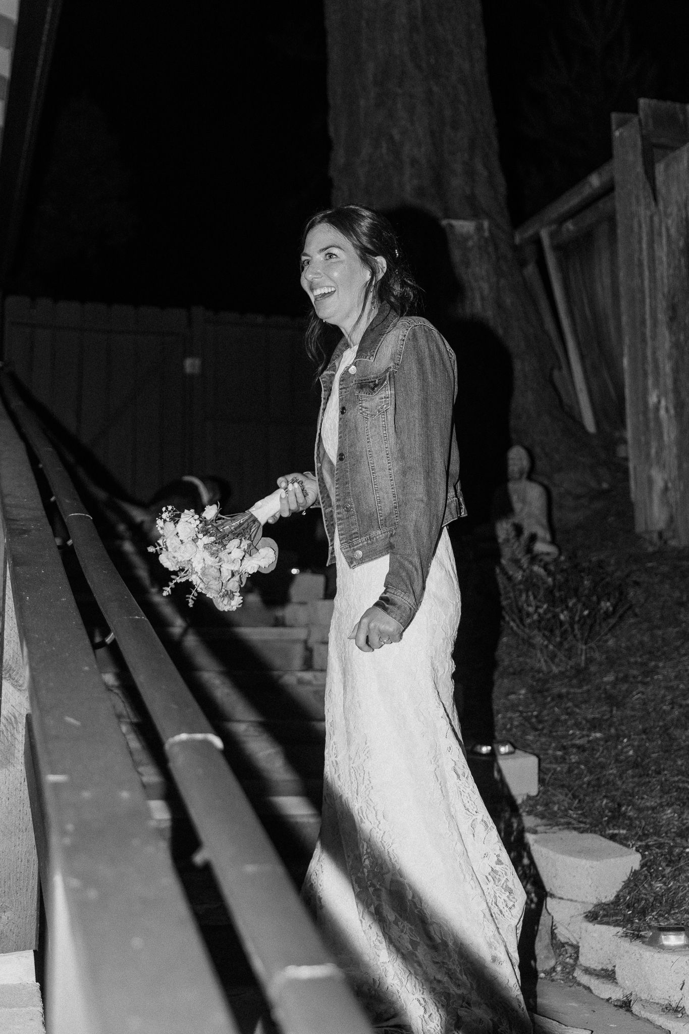Black and white nighttime photo on outdoor walkway during wedding celebration.