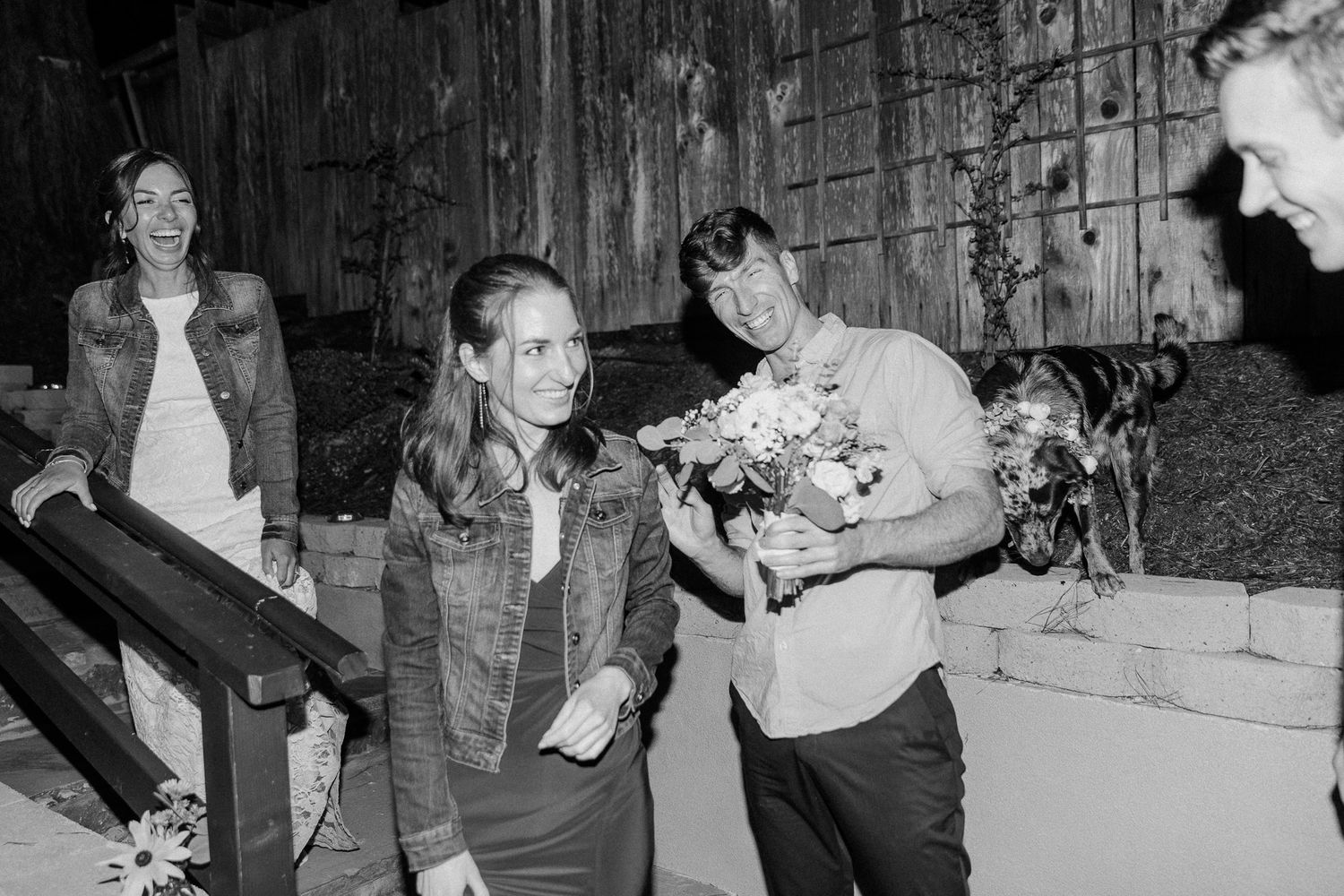 Black and white photo of outdoor nighttime gathering at rustic venue.