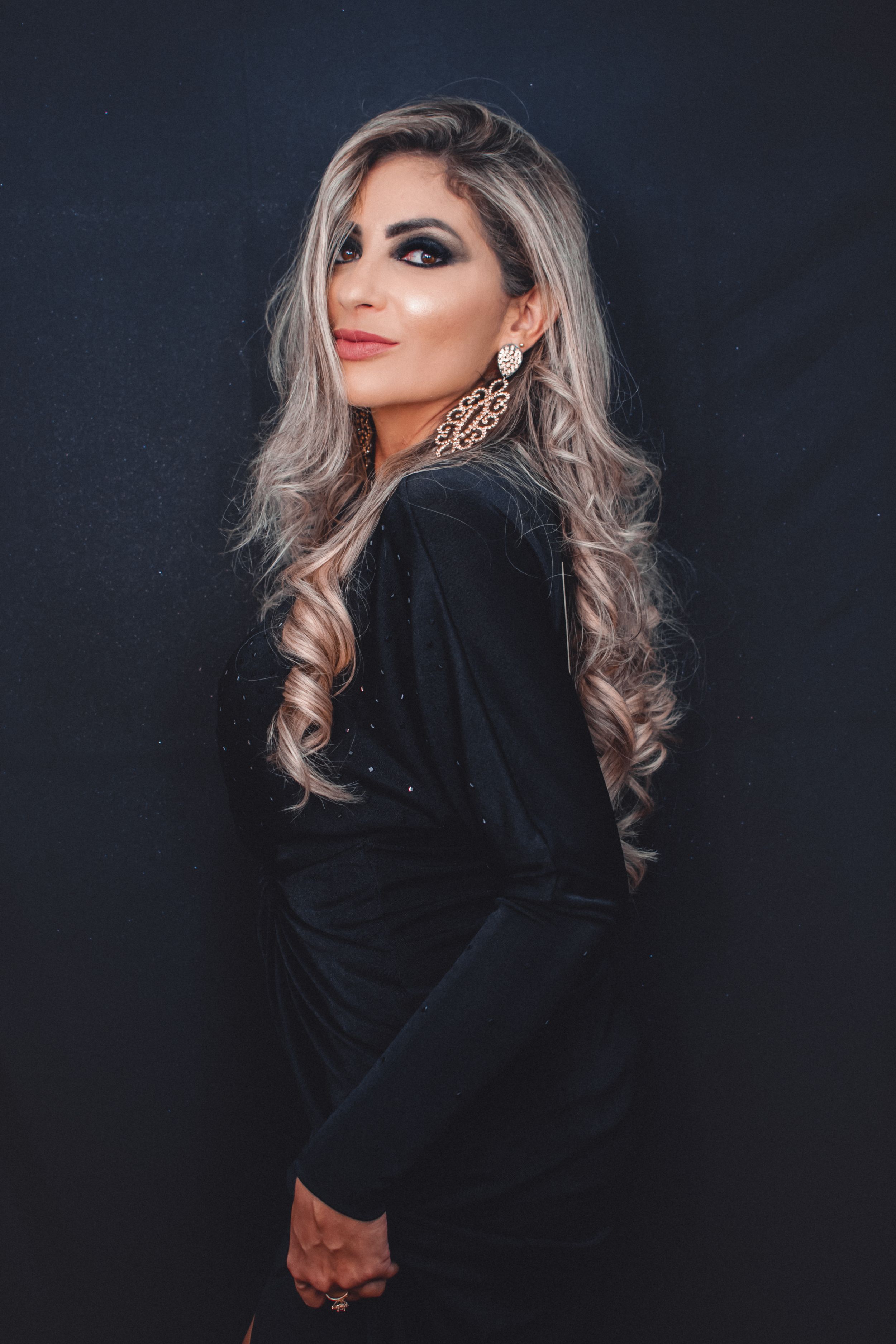 Glamour portraits in black velvet clothing with statement jewelry.
