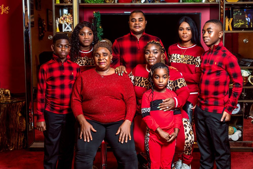 Family portrait with everyone dressed in coordinating red and black buffalo plaid outfits.