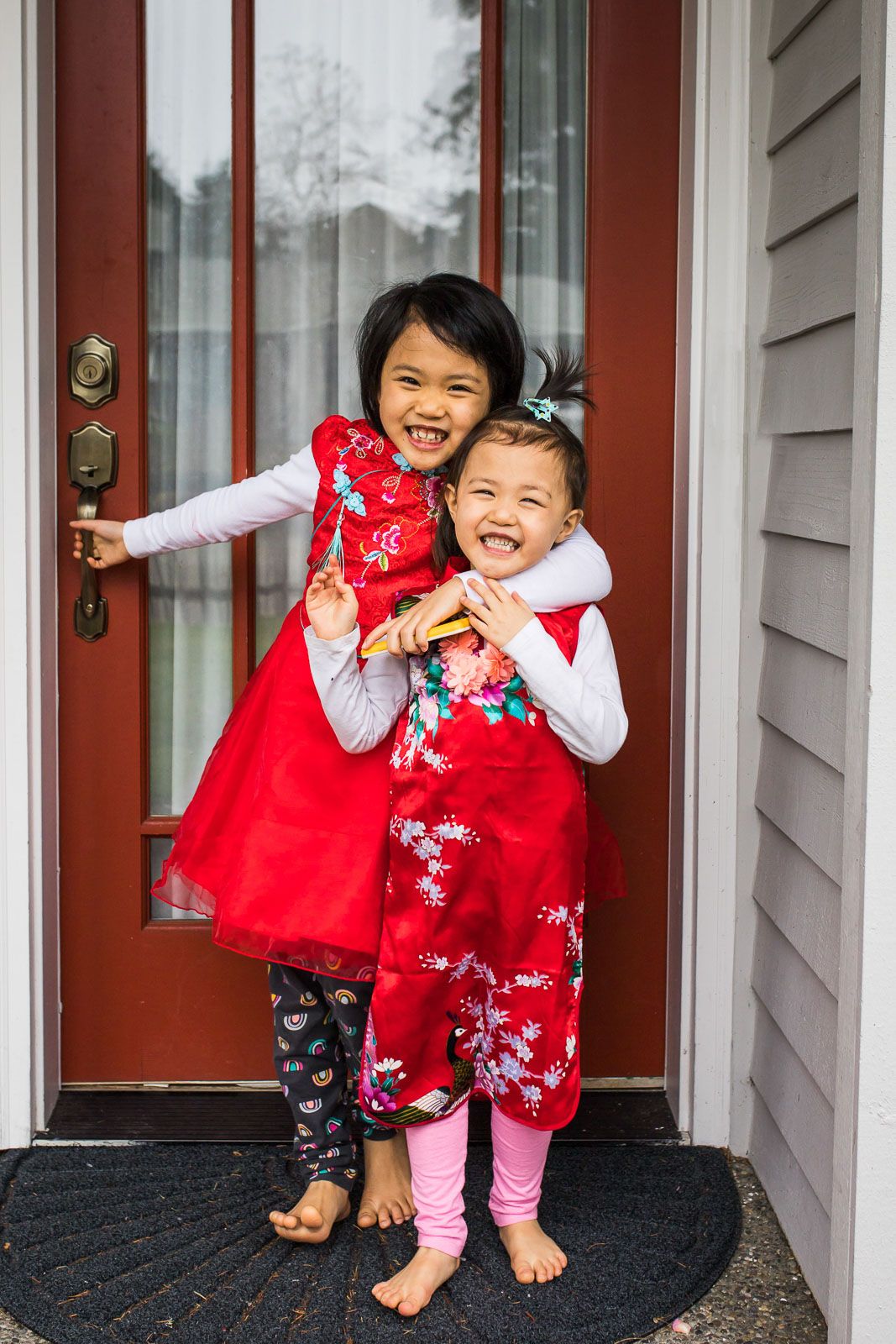 Ellie and JoJo in Chinese New Year clothes hugging each other