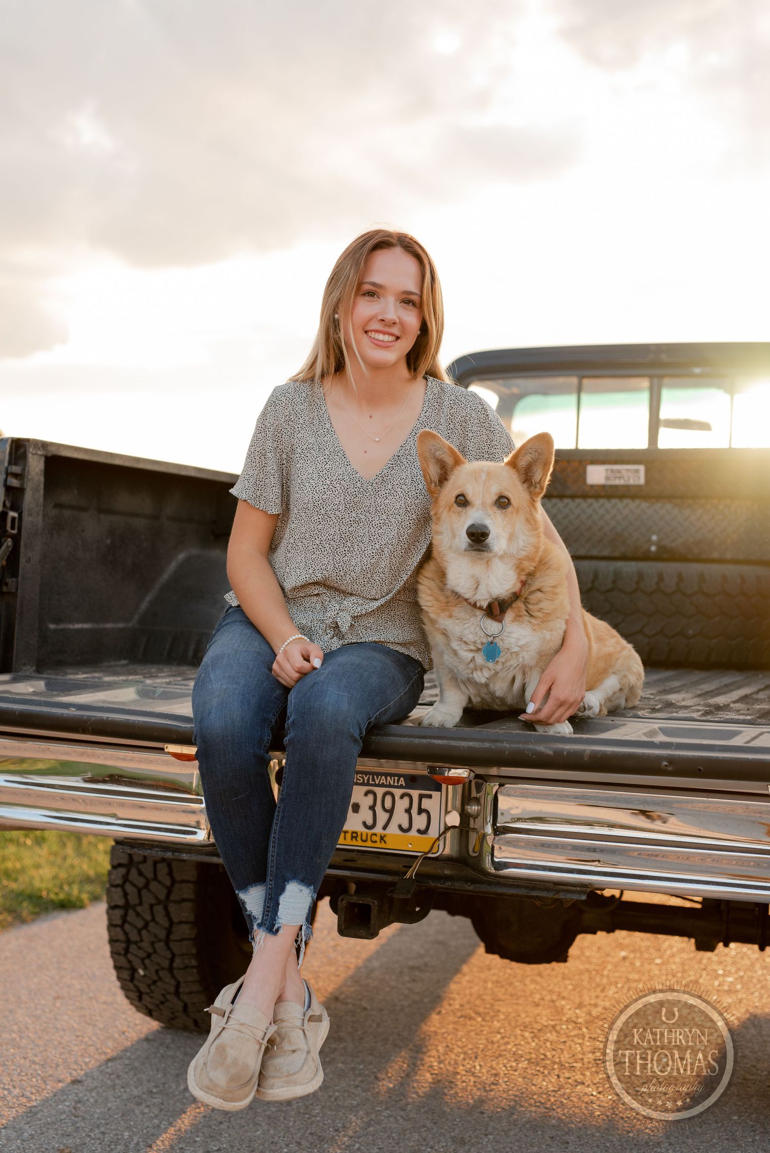Sunset portrait with corgi companion in pickup truck bed.