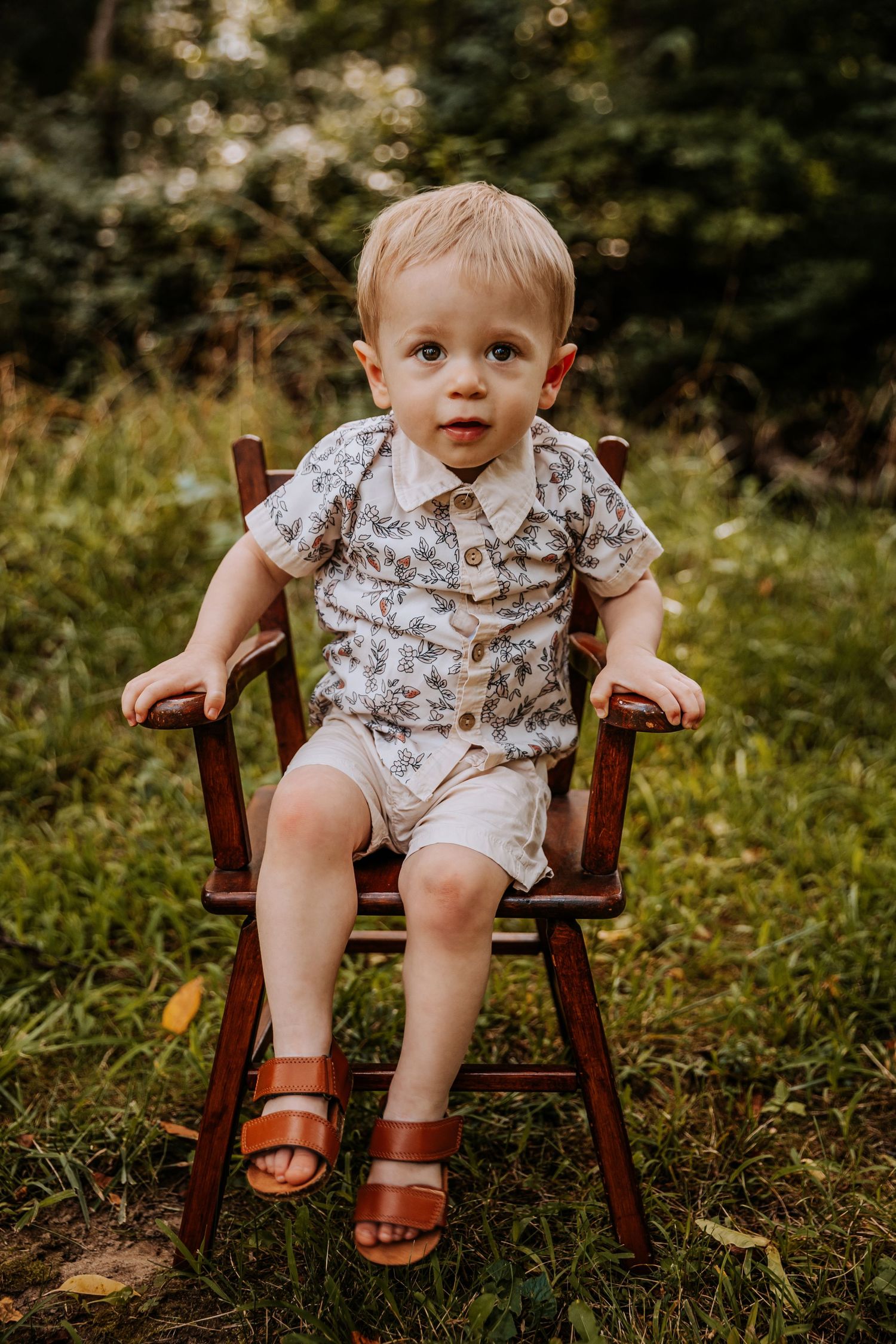 Vintage wooden chair in garden setting with floral pattern clothing.