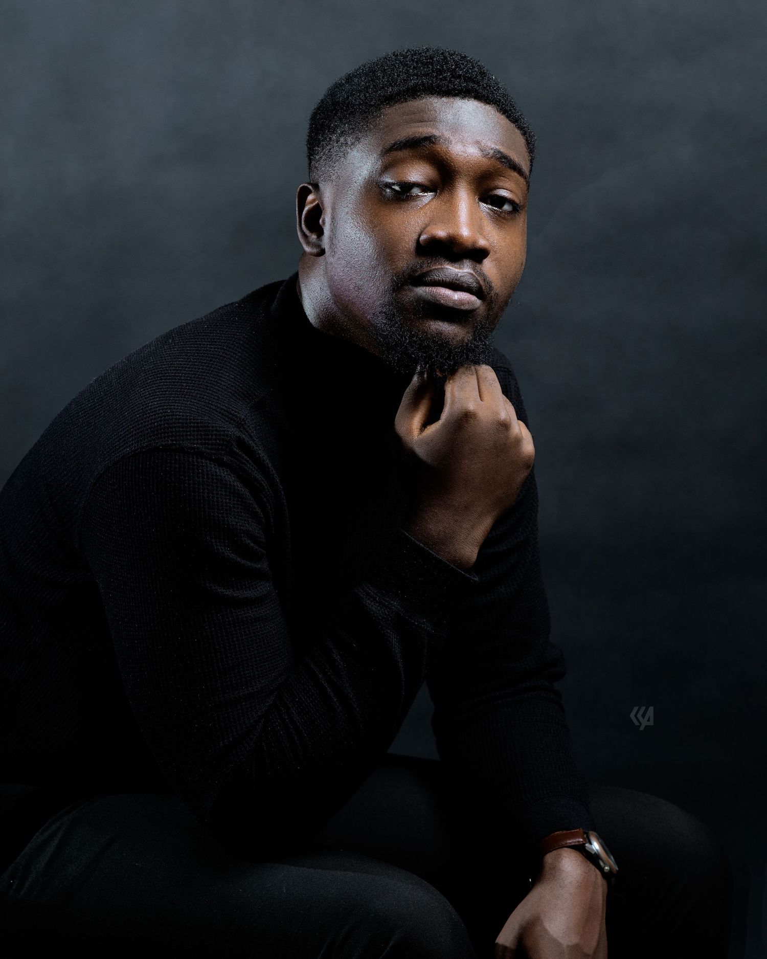 Dramatic black and white portraits against dark background showing contemplative poses.