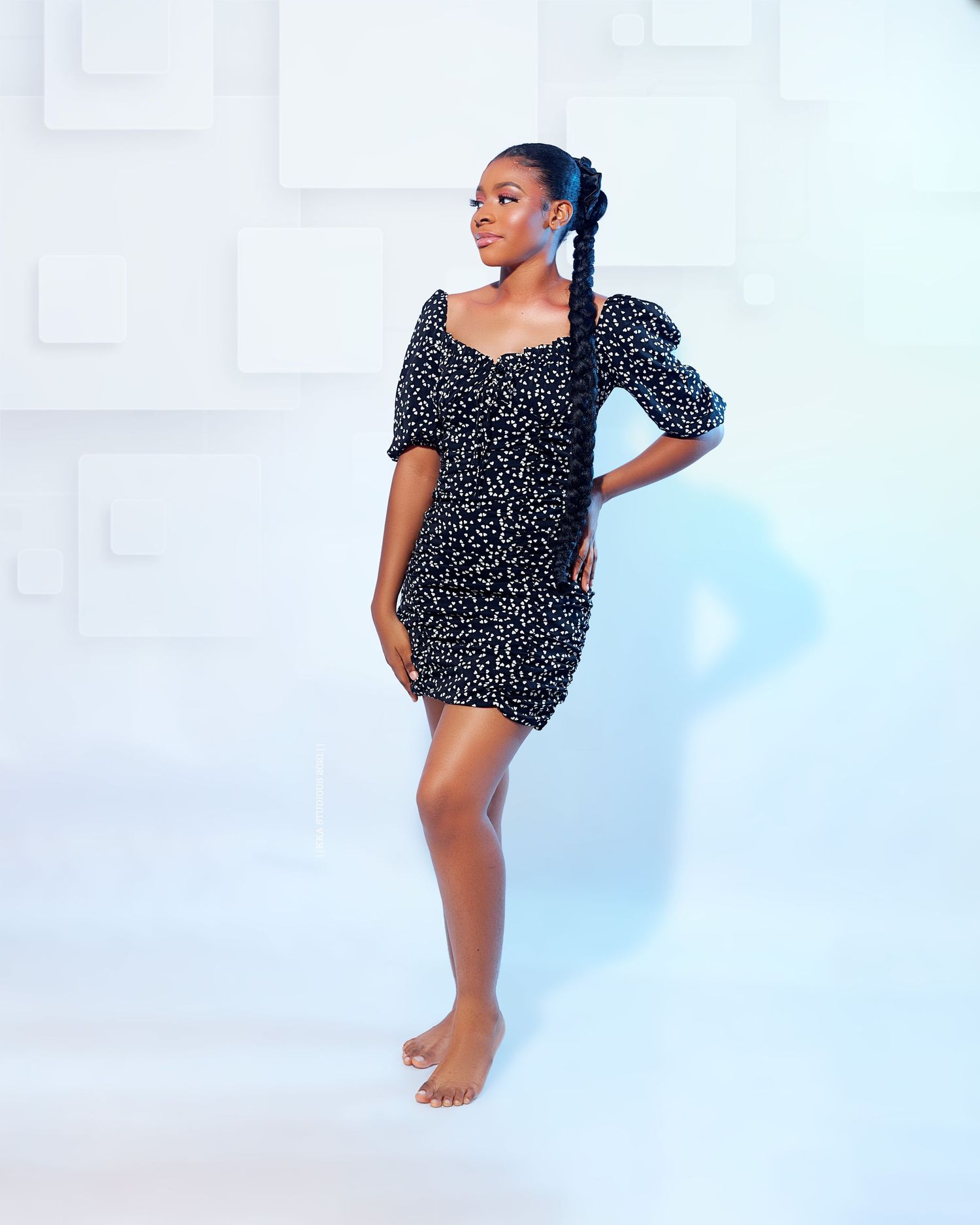 Woman in polka dot dress poses against light blue background in dynamic dance-inspired positions.