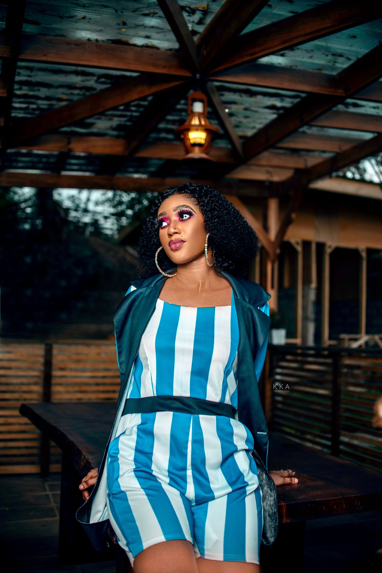 Fashion shoot in blue and white striped outfit under covered outdoor location.